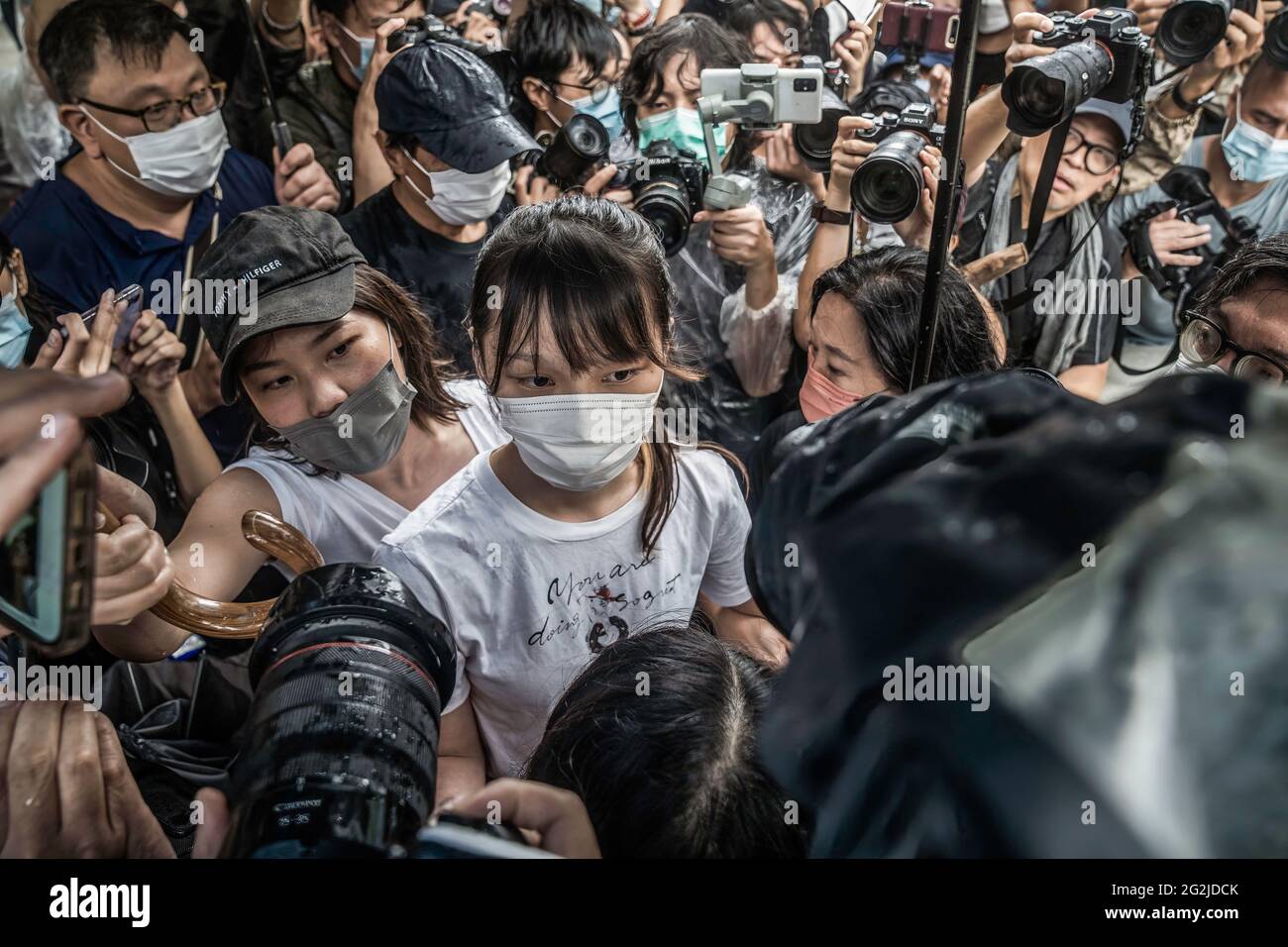 Hongkong, China. Juni 2021. Agnes Chow (C) geht durch das Medienpaket, nachdem sie aus der Tai Lam Correctional Institution entlassen wurde.die prodemokratische Aktivistin Agnes Chow wurde aus dem Gefängnis entlassen, nachdem sie fast sieben Monate lang wegen ihrer Rolle in einer nicht autorisierten Versammlung während der regierungsfeindlichen Proteste der Stadt im Jahr 2019 gedient hatte. Kredit: SOPA Images Limited/Alamy Live Nachrichten Stockfoto