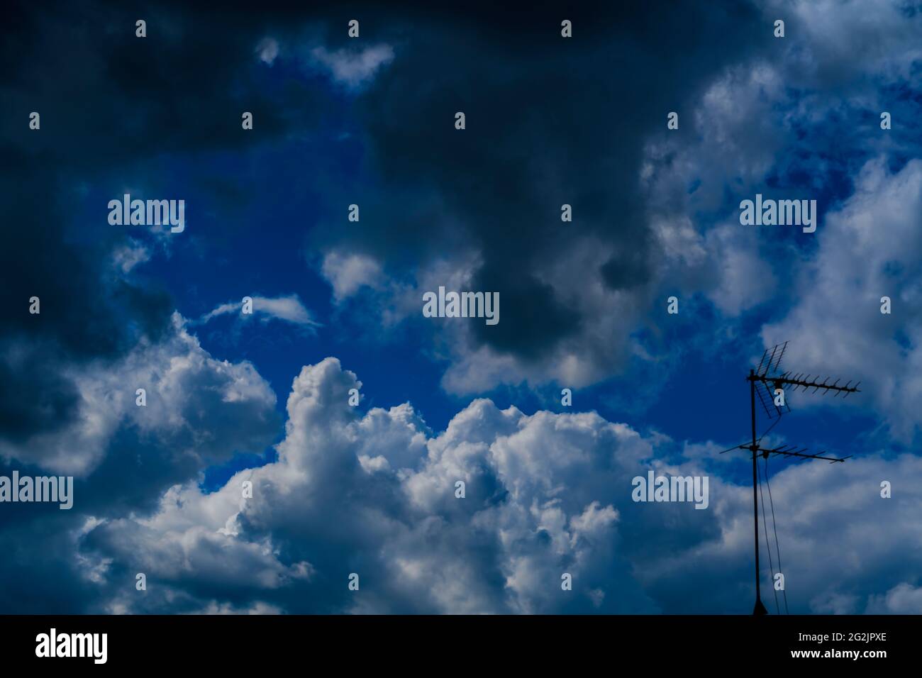 Cumulonimbuswolken in deutschland, im Vordergrund eine TV-Antenne Stockfoto