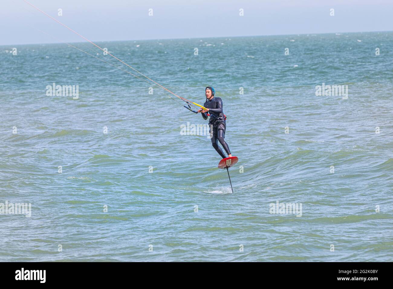 Ein Mann Hydrofoil Surfen auf dem Englischen Kanal in der Nähe von Hythe, Kent, Großbritannien Stockfoto