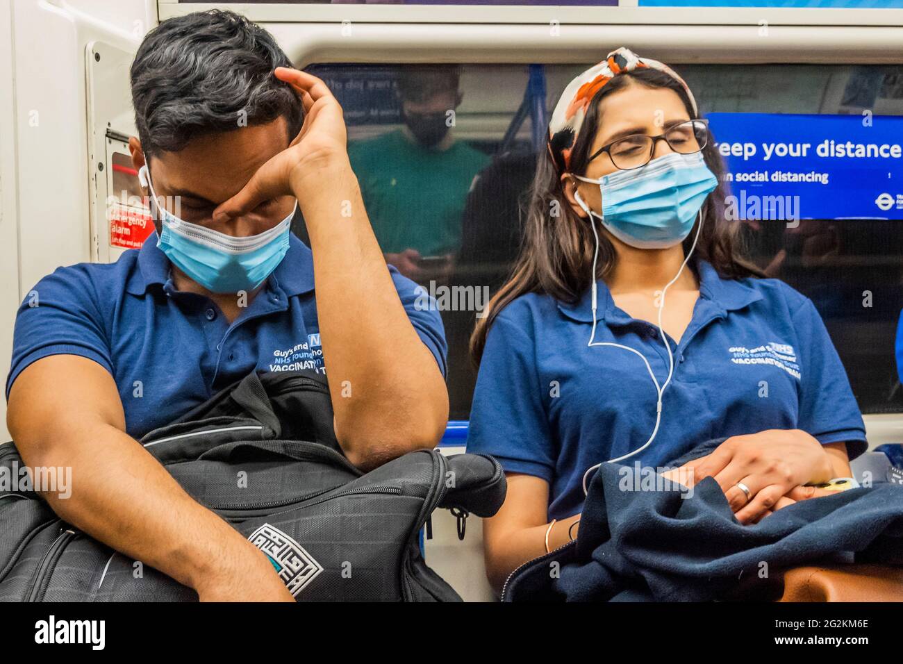 London, Großbritannien. Juni 2021. Erschöpfte Mitglieder des Impfteams von Guy's und St. Thomas fahren in der Londoner U-Bahn nach Hause. Kredit: Guy Bell/Alamy Live Nachrichten Stockfoto