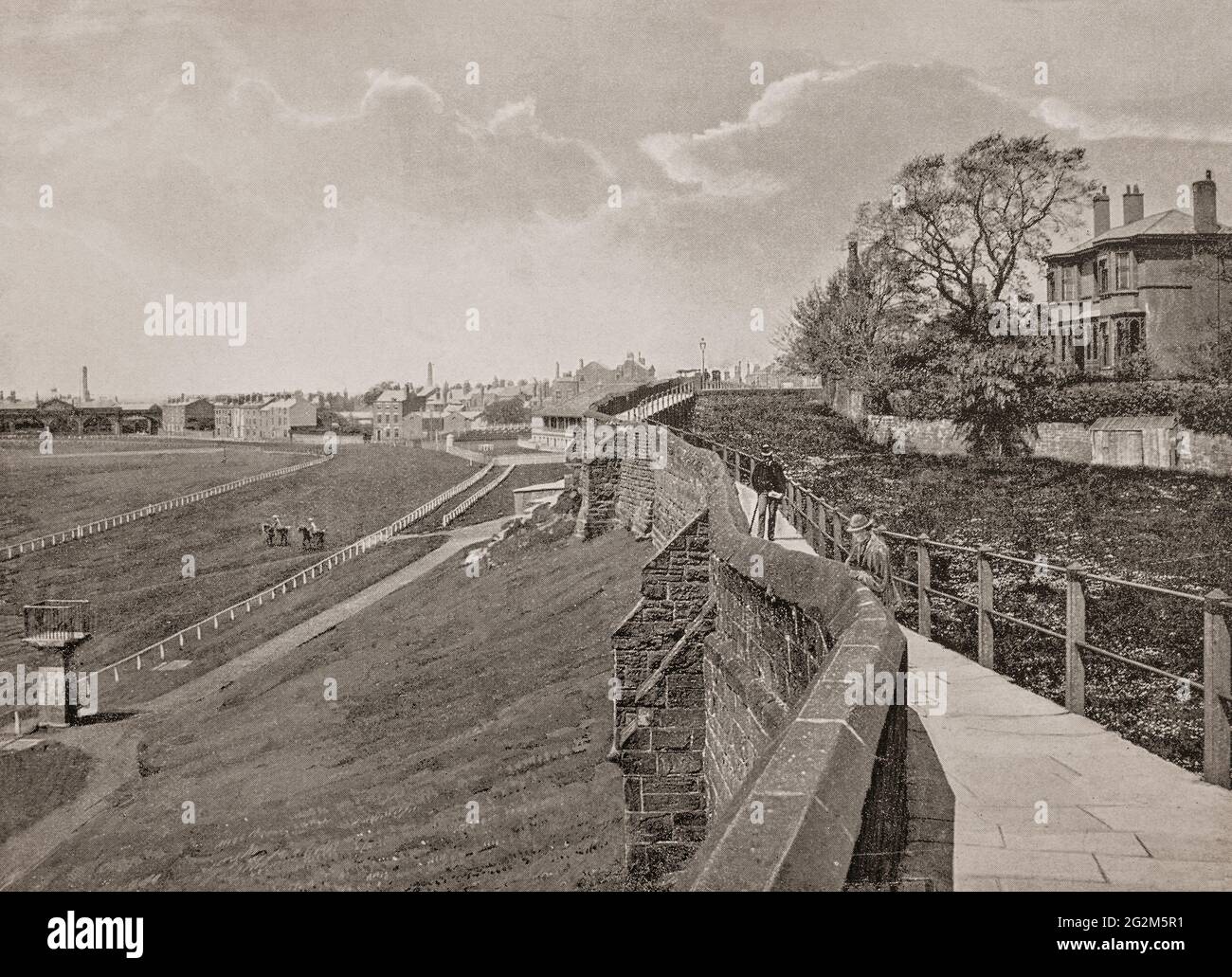 Eine Ansicht der Rennbahn von Chester aus dem späten 19. Jahrhundert und der römischen Mauer um die Domstadt in Cheshire, England. Deva Victrix wurde als "Castrum" oder römische Festung in der Regierungszeit des Imperators Vespasian im Jahr 79 n. Chr. gegründet. Die Mauern umschließen die Grenzen der mittelalterlichen Stadt und stellen die vollständigste Stadtmauer in Großbritannien dar. Stockfoto
