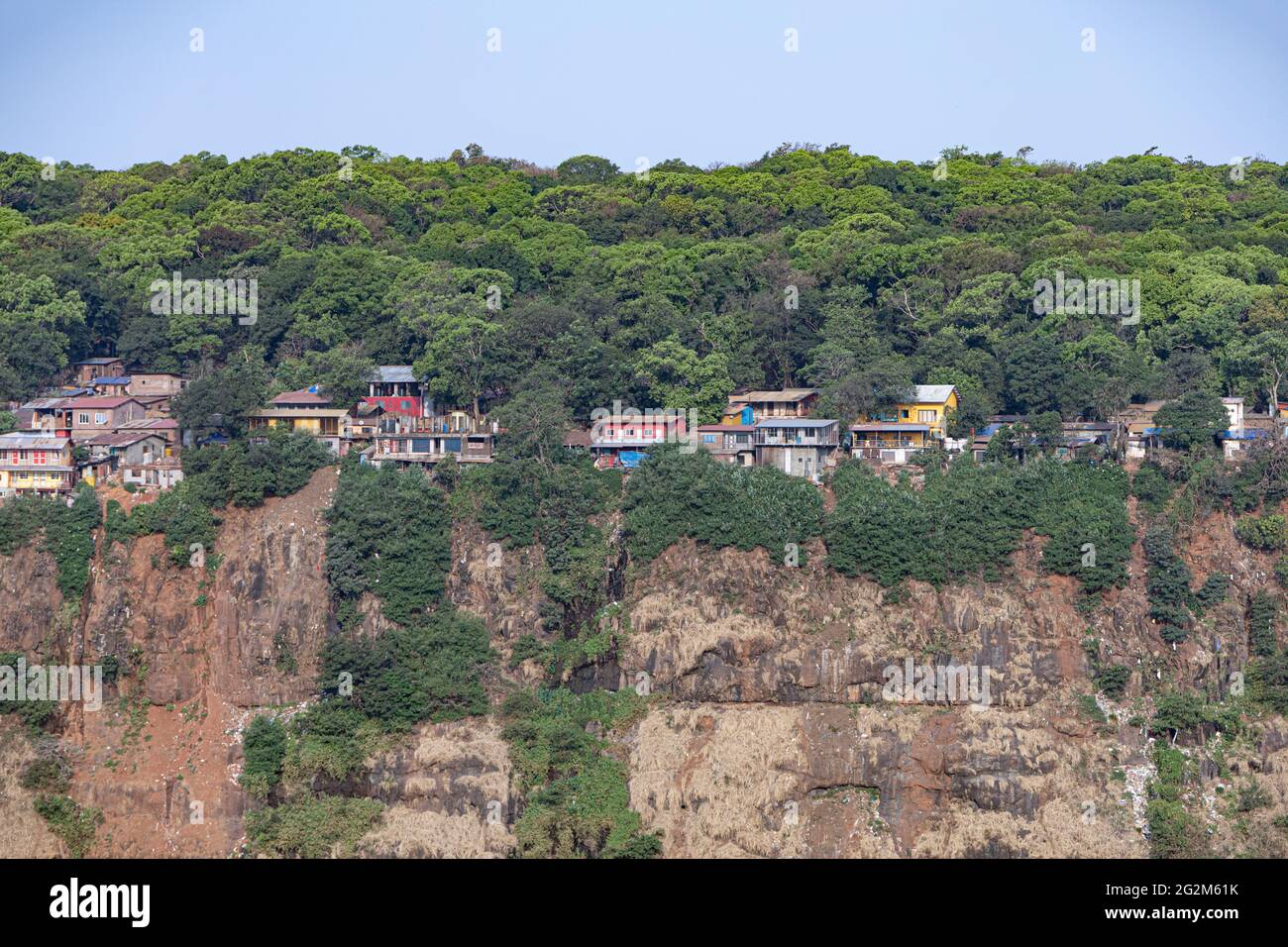 Landschaftlich schöner Blick auf die Häuserzeilen am Rande einer Klippe mit dichtem Wald im Hintergrund Stockfoto