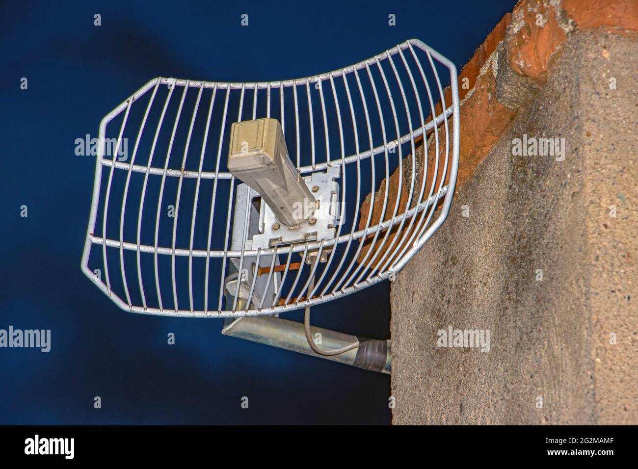 Ein am Kamin montierter WLAN Access Point für den Außenbereich. Eine Antenne für das Internet in der Dämmerung. Stockfoto