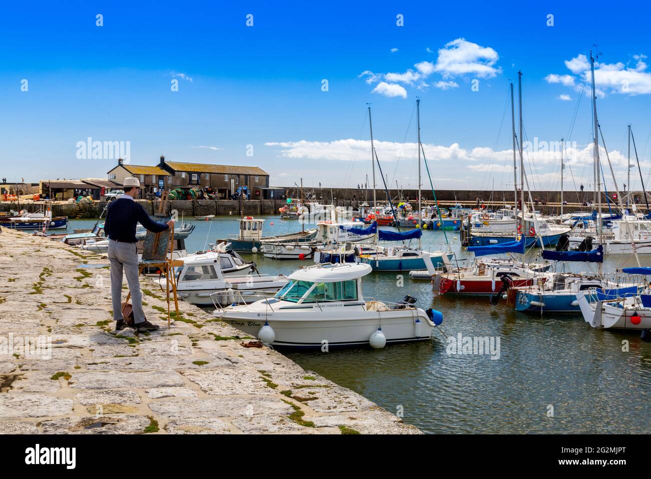 Ein Aquarell-Künstler fängt die Szene bei Flut im Hafen von Lyme Regis an der Jurassic Coast, Dorset, Großbritannien, ein Stockfoto