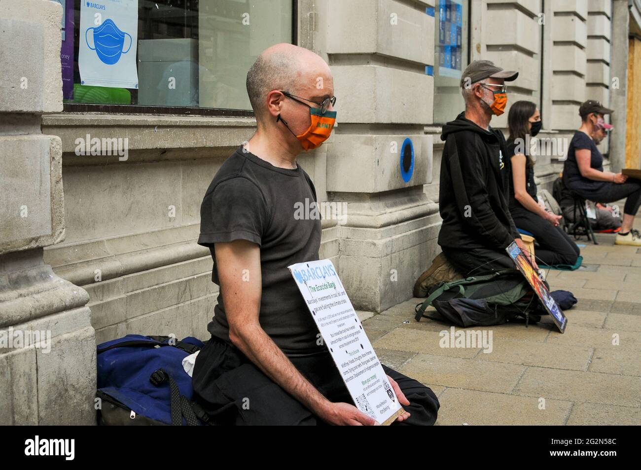 Cambridge, Großbritannien, England, 12-062021, XR-Aktivisten führten eine Meditation in der Bank durch, während andere draußen auf der Straße Performances inszenierten. Auf den selbstgemachten Bannern stand „Barclays: The Ecocide Bank“, „HSBC: We are Climate Crisis“, „Lloyds Bank: Rampping up Fossil Investment“, „NatWest: Funding Fracking and Tar Sands“ und „Santander: Because our Shareholders are More important than you“. Eine Samba-Band nahm ebenfalls an dem Protest Teil Stockfoto