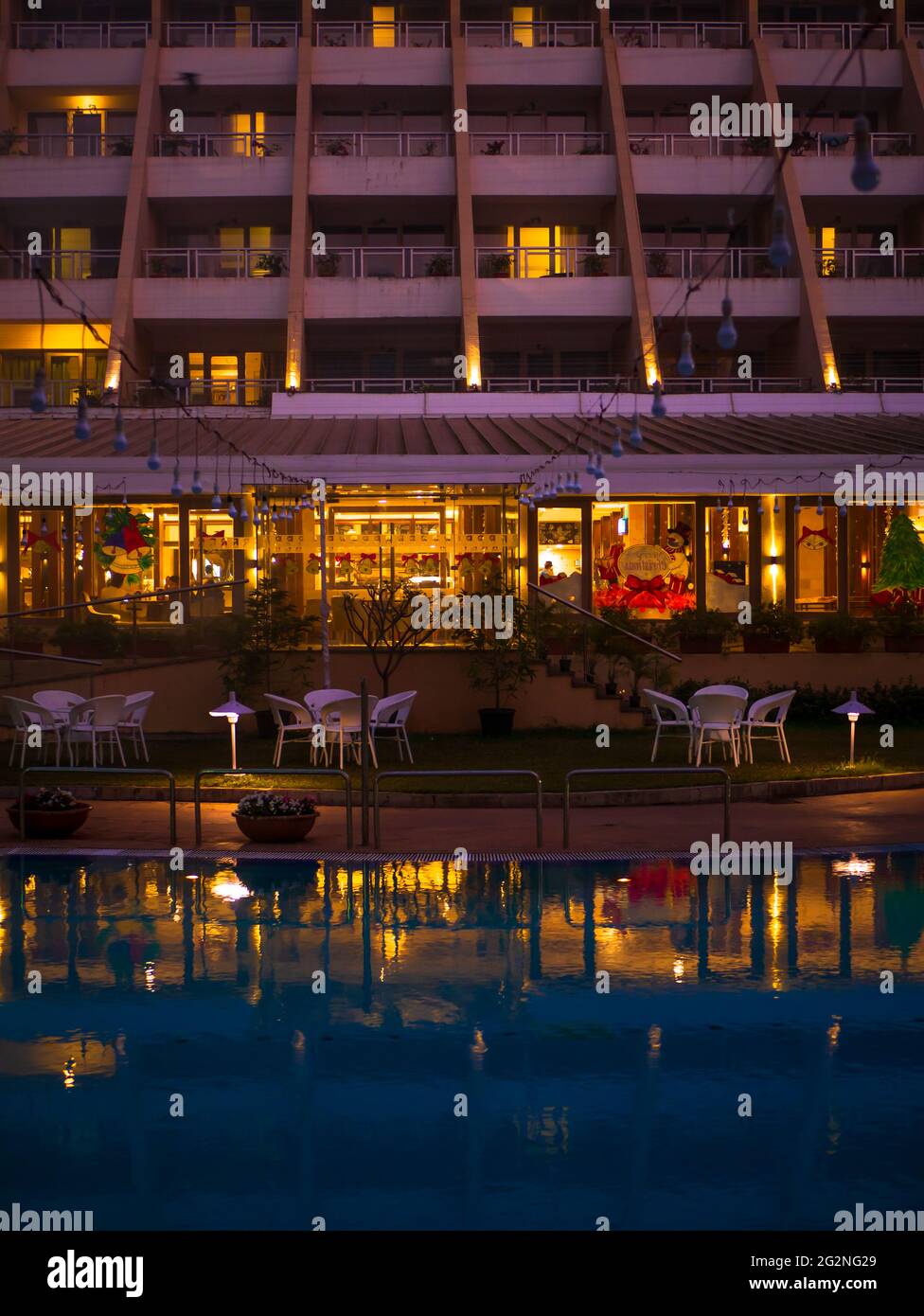 MUMBAI, INDIEN - 31. Dezember 2021: Luxuriöses Hotel mit Blick auf den Pool und Lichtreflexion des Restaurants im Poolwasser Stockfoto