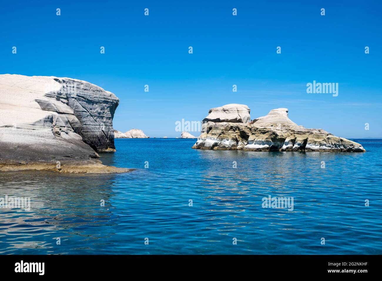 Insel Milos, Sarakiniko. Kykladen Griechenland. Mondlandschaft. Weiße Felsformationen, Klippen und Höhlen, blaues, gewelltes Meer und klarer Himmel im Hintergrund. Stockfoto