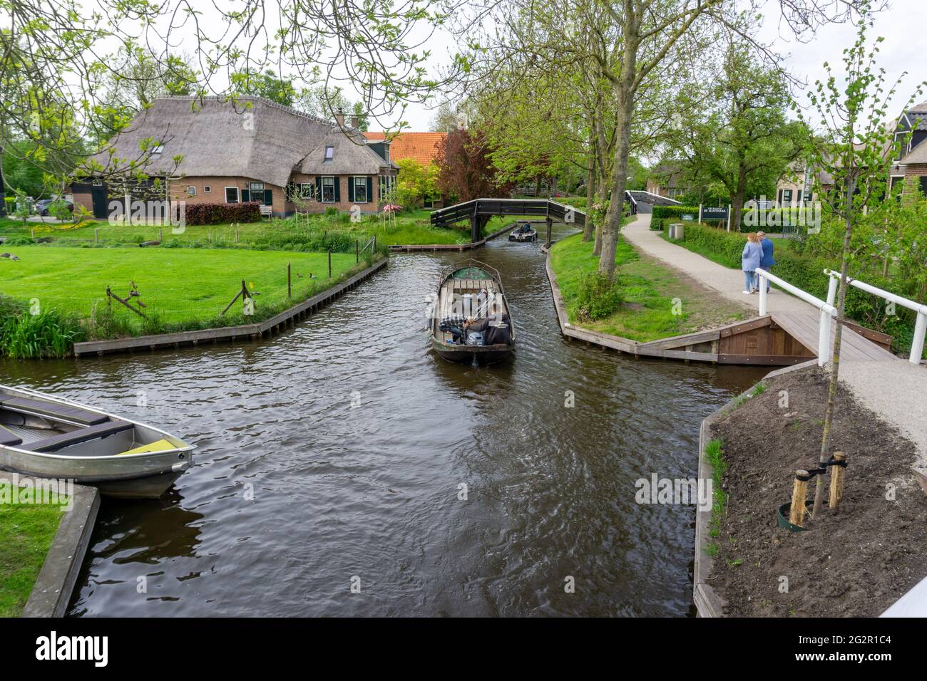 Giethoorn, Niederlande - 23. Mai 2021: Mann steuert ein Boot durch die Kanäle des Dorfes Giethoorn, auch bekannt als holländisches Venedig Stockfoto