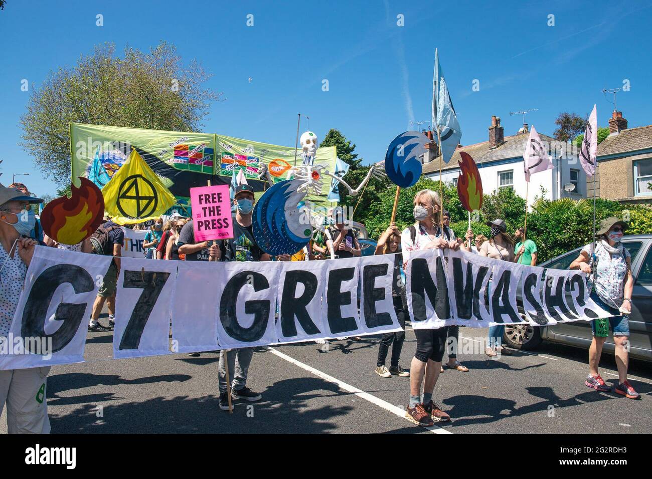 Falmouth, Cornwall, Großbritannien 2021 12. Juni ‘Aussterbungsrebellion marschiert aus Protest gegen die „Greenwashing“-Politik von Wirtschaft und Regierung beim G7-Gipfel. Die roten Rebellen führten den marsch durch das Stadtzentrum, zusammen mit den Ärzten von XR und schmutzigen Wäschern, und endeten am Medienzentrum. Stockfoto