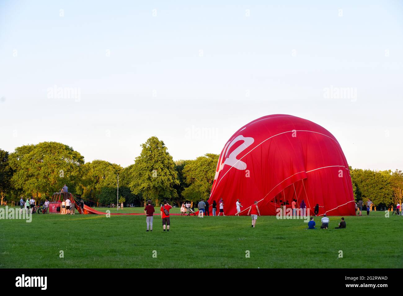 12. Juni 2021 - Northampton - UK = Virgin Hotair Ballon Rides landet auf dem Rennbahnpark, während die Menge zuschaut, wie es entflat Stockfoto