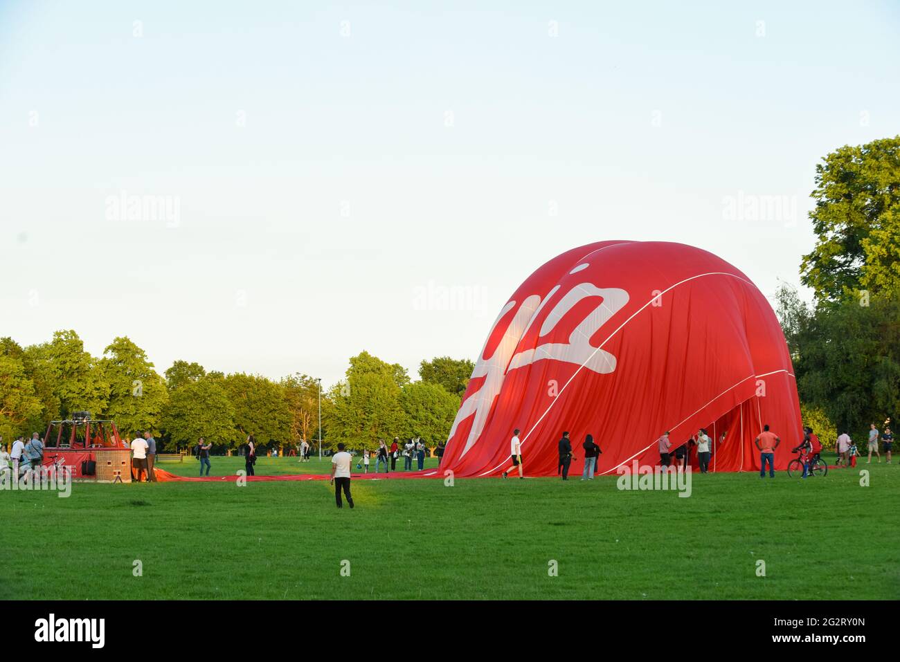 12. Juni 2021 - Northampton - UK = Virgin Hotair Ballon Rides landet auf dem Rennbahnpark, während die Menge zuschaut, wie es entflat Stockfoto