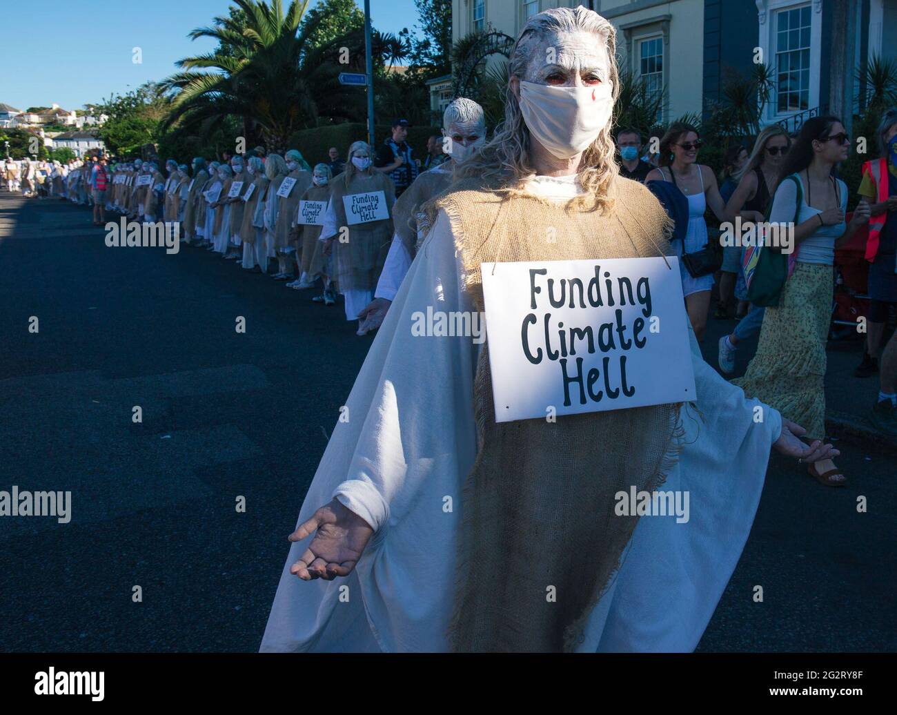 Falmouth, Cornwall, Großbritannien 12. Juni 2021 Extinction Rebellion Demonstranten kleiden sich als G7-Gipfel der „Büßer“. Die Büßer basieren auf der mittelalterlichen Idee der Sühne für Übertretungen gegen die Gemeinschaft, sie tragen die Verbrechen der heutigen Welt in ihre eigenen. Stockfoto