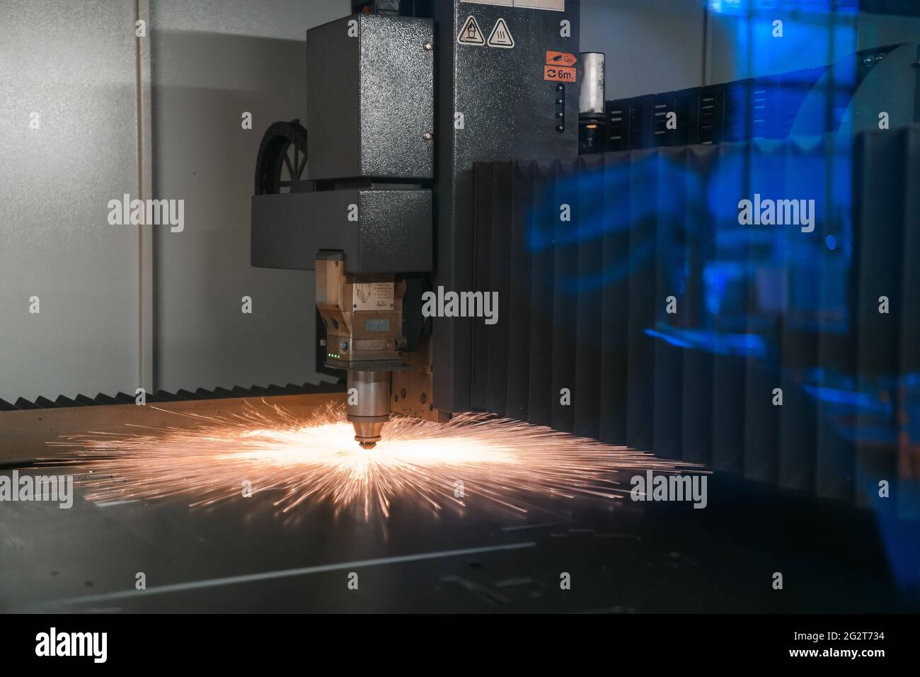 Funken fliegen, Machine Head für die Metallverarbeitung laser Metall auf Hütten- Hintergrund. Herstellung von Fertigteilen für die Automobilproduktion Stockfoto