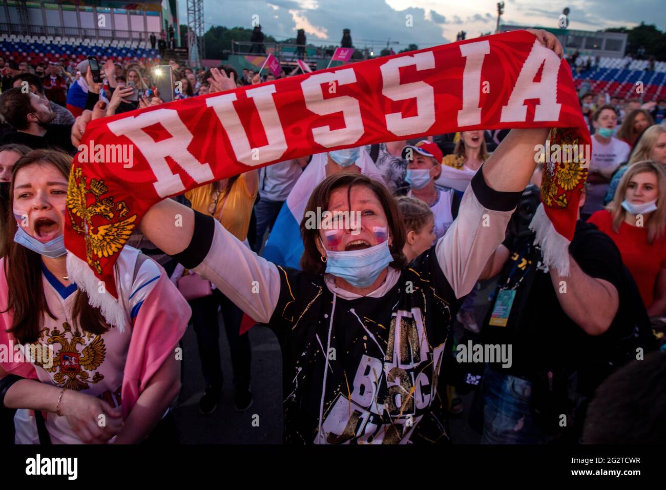 Moskau, Russland. 12. Juni 2021 Russische Frauen mit Gesichtsmasken unterstützen die russische Fußballnationalmannschaft während des UEFA Euro 2020 Gruppe B-Spiels zwischen Belgien und Russland in der Fanzone im Luzhniki-Stadion in Moskau, Russland Stockfoto