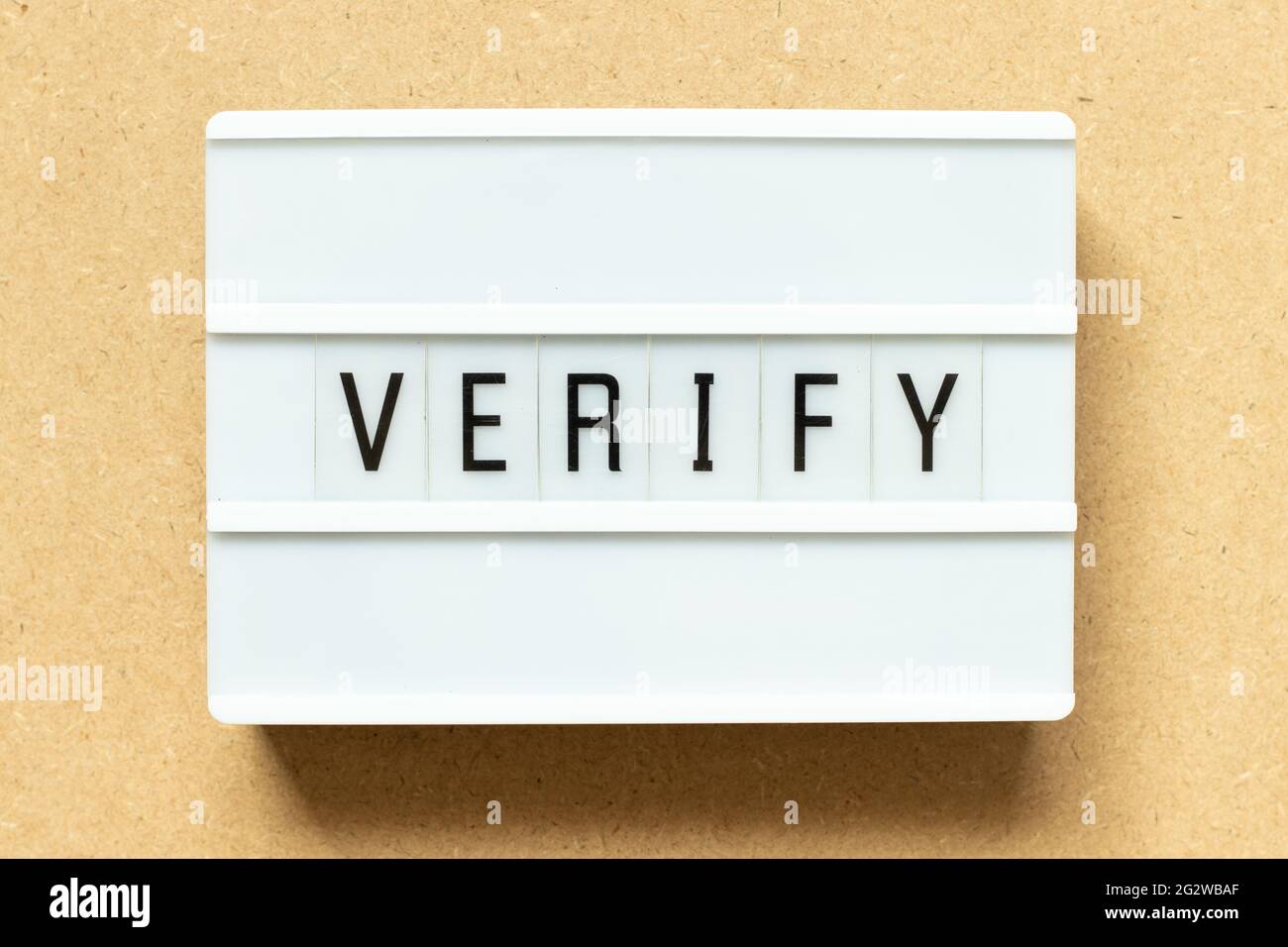 Leuchtkasten mit Wort verifizieren auf Holzhintergrund Stockfoto