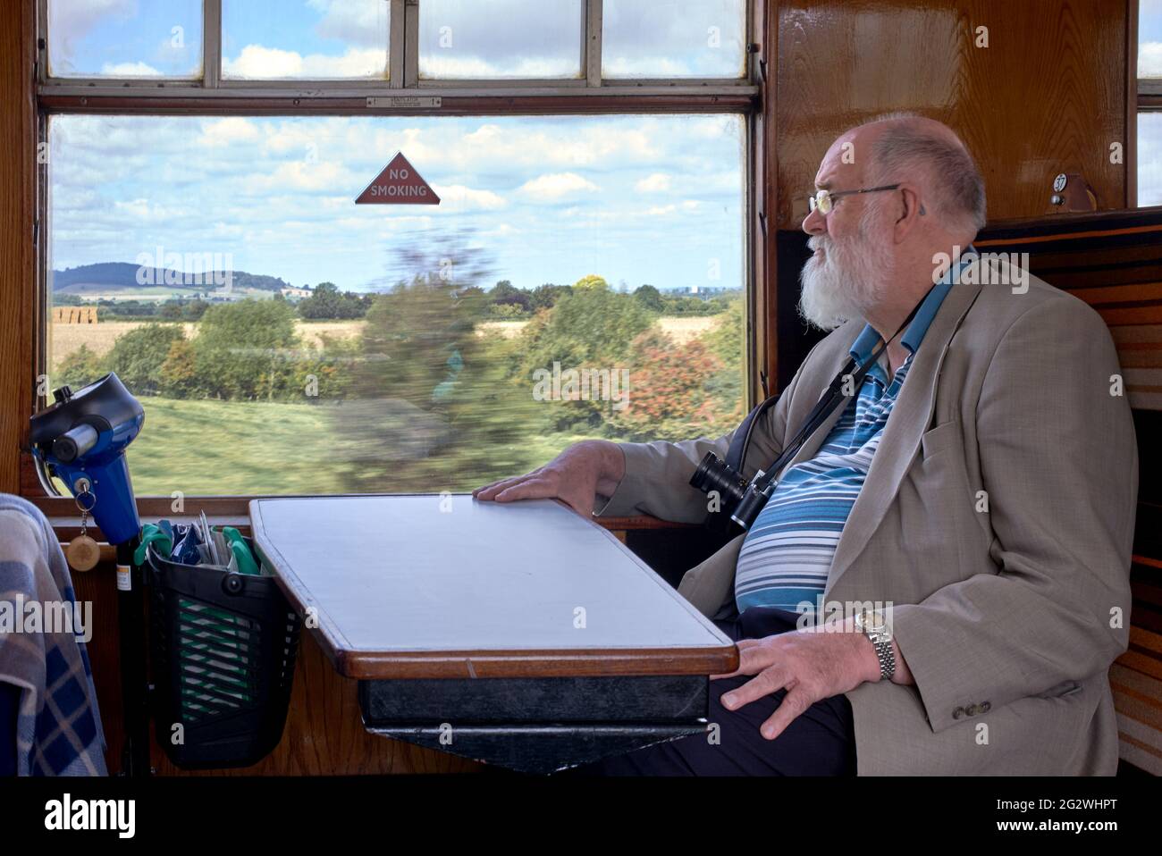 Der Seniorenzug fährt mit einem Bürger an Bord des alten GWR-Dampfzuges, der durch die englische Landschaft fährt. England, Großbritannien. Stockfoto