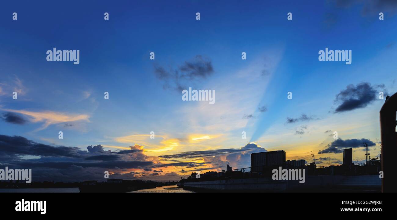 Blaue „crepuscular waves“ bei Sonnenuntergang auf dem Fluss (Panorama) Stockfoto