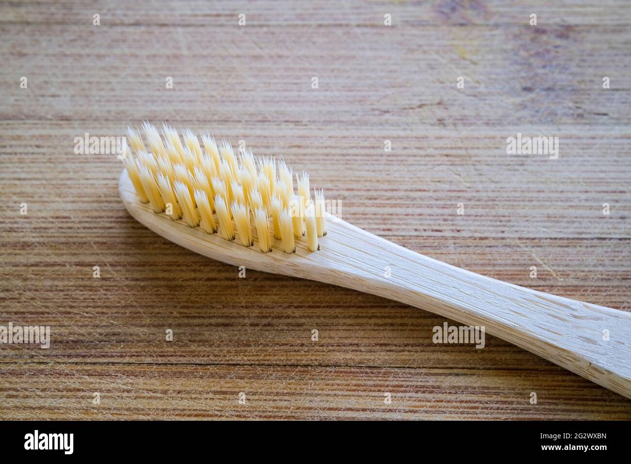 Zahnbürste aus Bambus auf einem hölzernen Hintergrund Stockfoto
