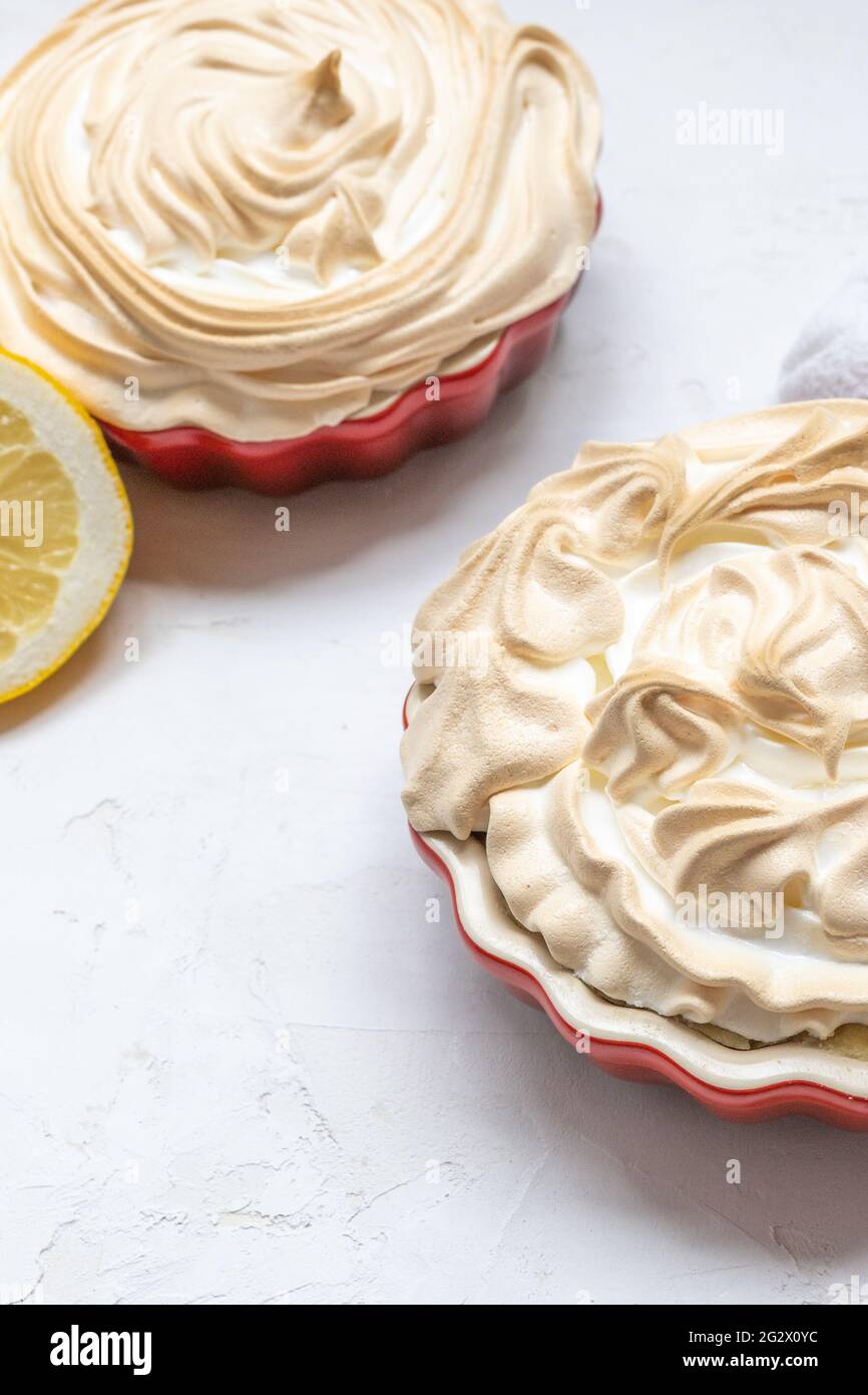 Zwei Zitronen-Meringue-Törtchen in roten Mini-Pie-Formen Stockfoto