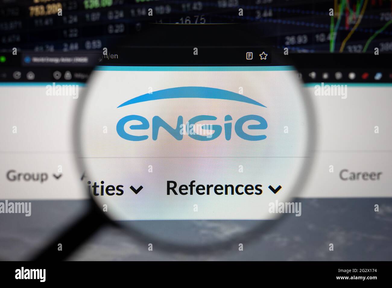 ENGIE-Firmenlogo auf einer Website mit verschwommenen Börsenentwicklungen im Hintergrund, die auf einem Computerbildschirm durch eine Lupe gesehen werden Stockfoto
