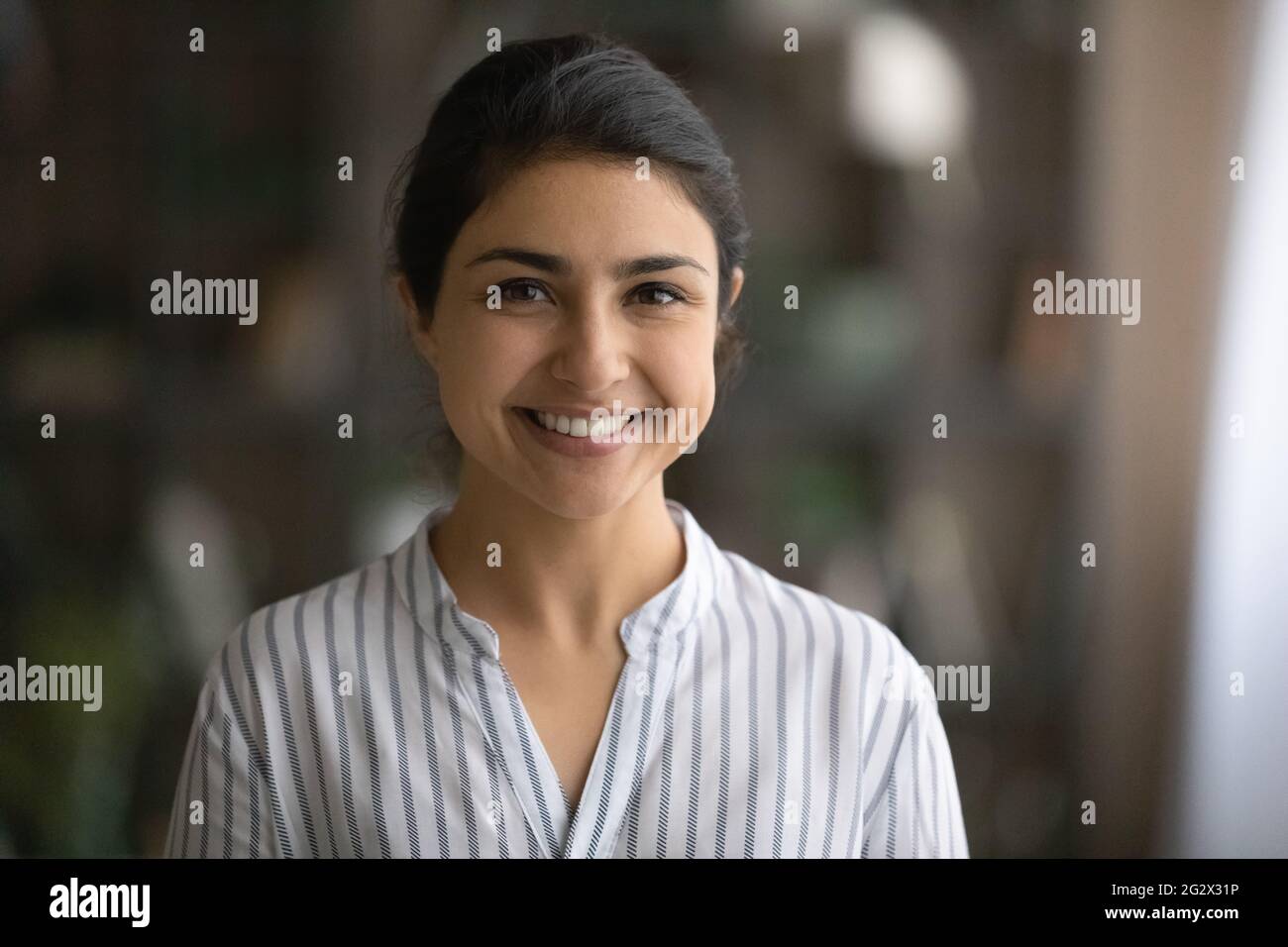 Innenporträt einer fröhlichen jungen indischen Geschäftsfrau Stockfoto