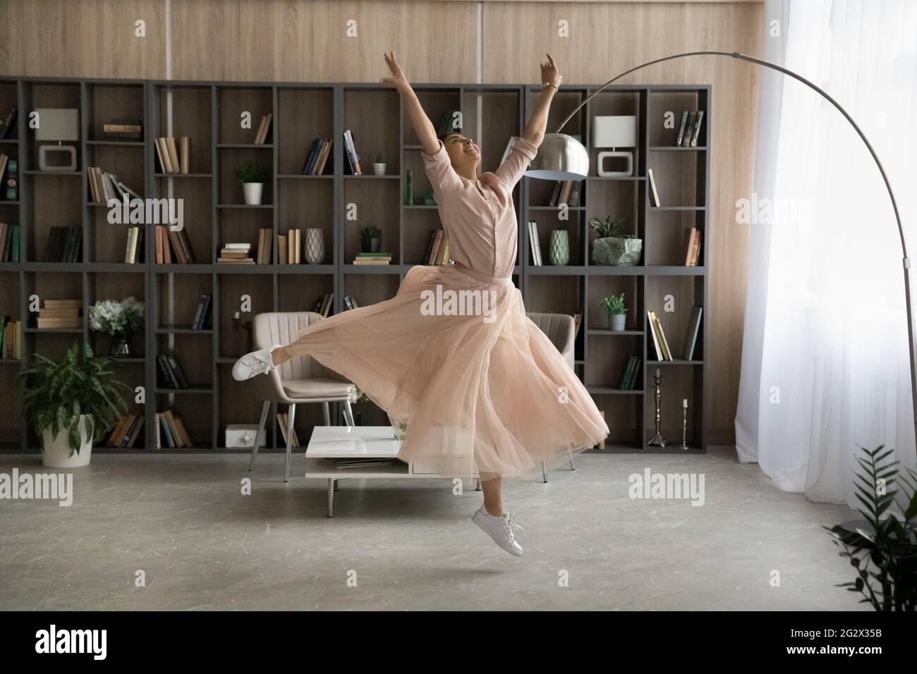 Inspiriertes jugendlich indisches Dame Tanz Ballett in großen modernen Wohnung Stockfoto