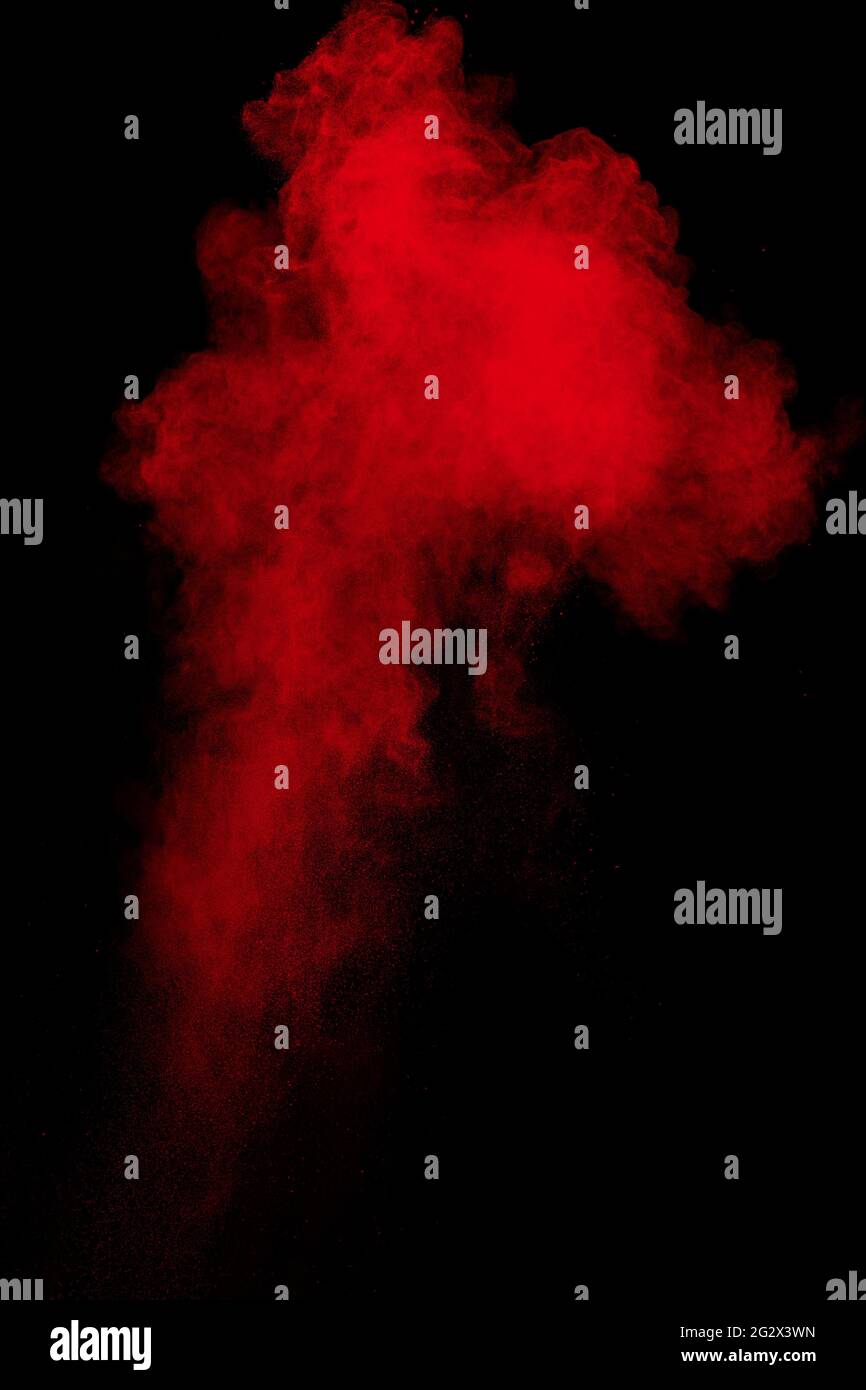 Explosionswolke aus rotem Pulver auf schwarzem Hintergrund. Stockfoto
