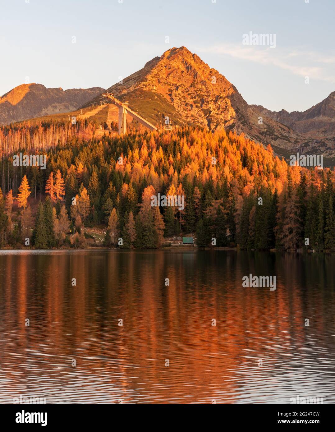 Der Strbske pleso See mit den Berggipfeln Predne Solisko, Mlynicke Solisko und Strbske Solisko im Vysoke Tatry Gebirge in der Slowakei am Herbstmorgen Stockfoto