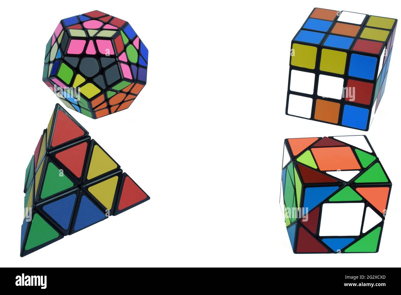 Vier Rubik's Würfel in verschiedenen Formen und Designs in verschiedenen Ecken des Rahmens auf weißem Hintergrund Stockfoto
