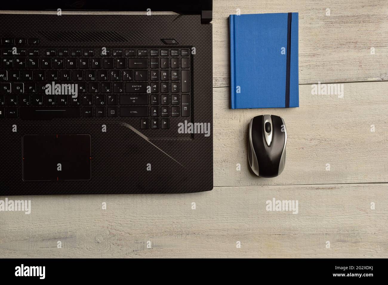 Laptop, Notebook und Maus liegen auf einem Holztisch Stockfoto