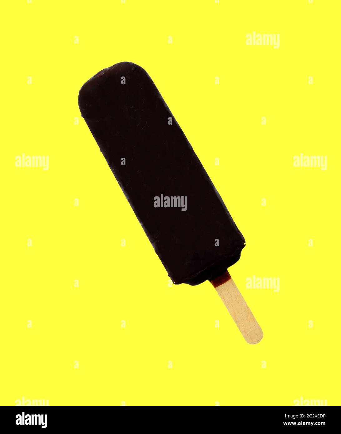 Schokoladeneis Lolly, Schokoladenglasur Nahaufnahme auf dem gelben isolierten Hintergrund. Eisdiele, im Sommer heiße Tage. Kaltes, leckeres Eis. Eislolly. Stockfoto