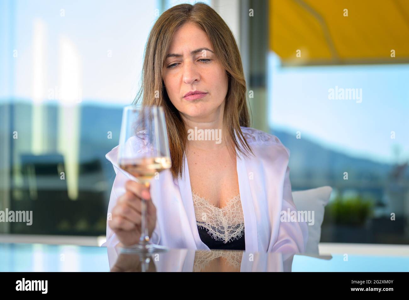 Besorgt zurückgezogen Frau sitzen starrte auf ein Glas Wein tief denkend Stockfoto