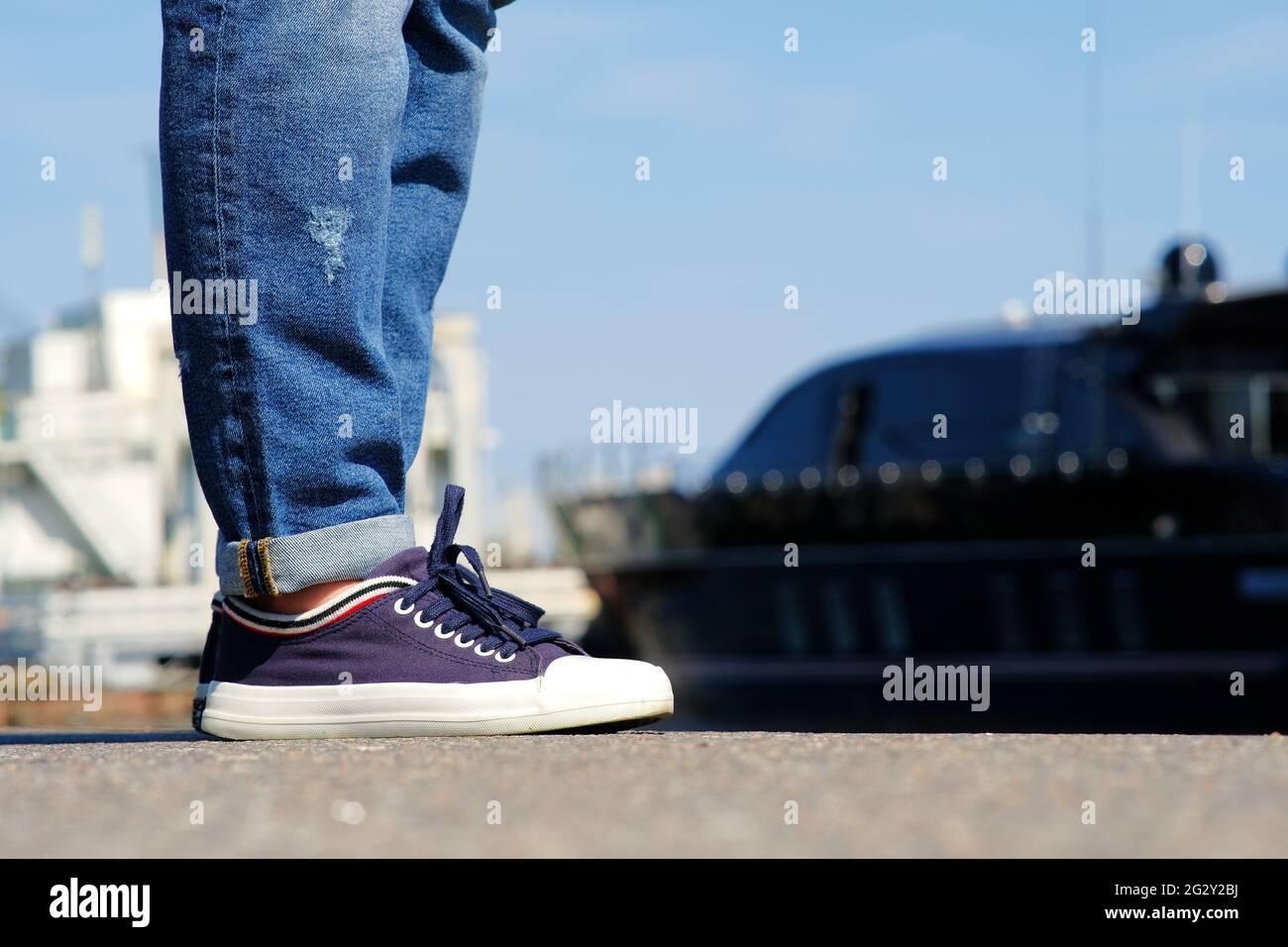 Auf Dem Pier Steht Ein Hipster Madchen In Modisch Zerrissenen Jeans Und Sneakers Stockfotografie Alamy