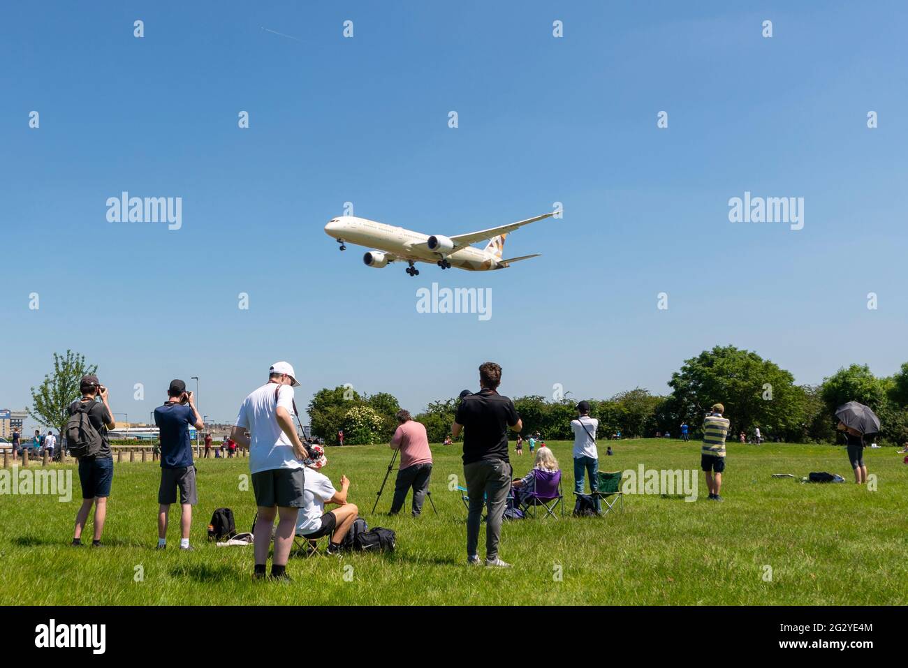 Flughafen London Heathrow, London, Großbritannien. Juni 2021. Luftfahrtbegeisterte versammeln sich an beliebten Orten in Heathrow, um die Boeing VC-25A (umgebauter Jumbo Jet aus dem Jahr 747) der „Air Force One“ zu fotografieren, die den US-Präsidenten Joe Biden vom G7-Gipfel in Newquay nach London transportiert. Normale Flugzeuge landen über ihnen. Das Wetter ist perfekt, mit klarem blauen Himmel. Stockfoto