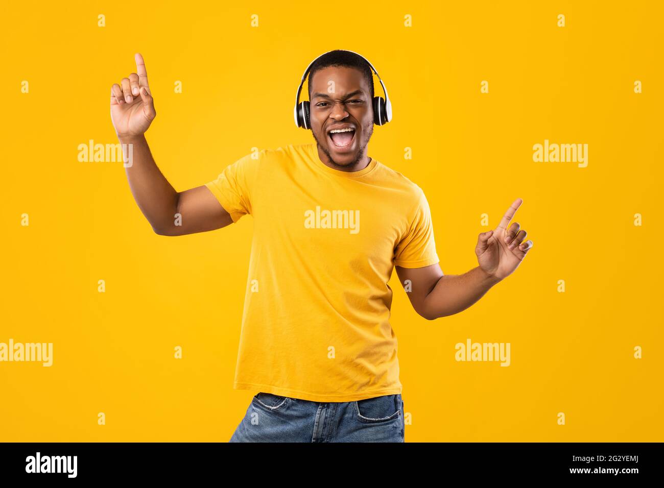 Black Guy Singen Und Tanzen Musik Hören, Gelber Hintergrund Stockfoto