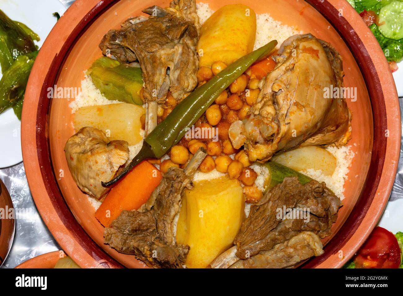 Traditionelles Berber Couscous Gericht mit Fleisch, Kartoffeln, Kichererbsen, Zucchini und Soße serviert in Tajine Stockfoto
