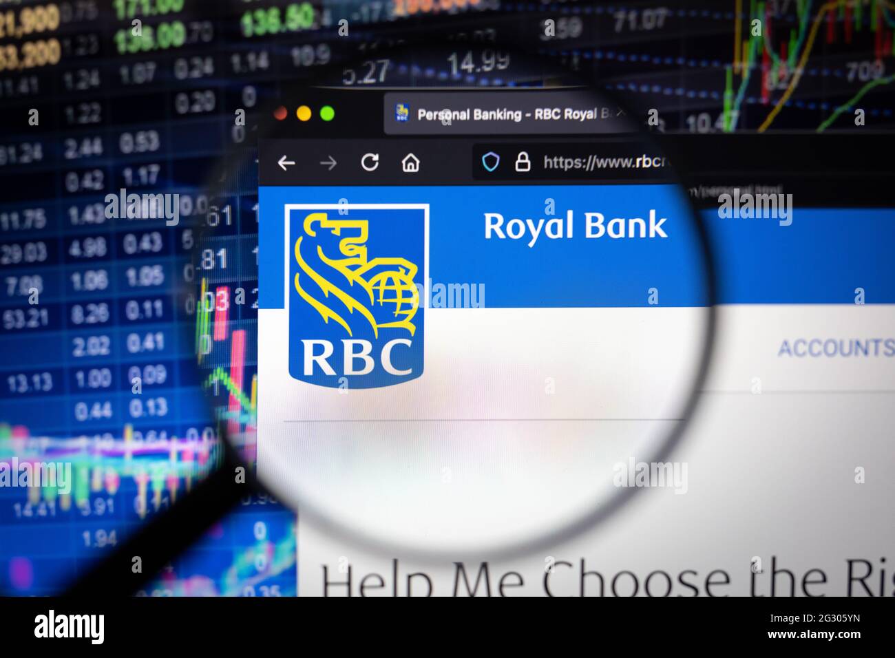 Logo der RBC Royal Bank auf einer Website mit verschwommenen Börsenentwicklungen im Hintergrund, die auf einem Computerbildschirm durch eine Lupe gesehen werden Stockfoto