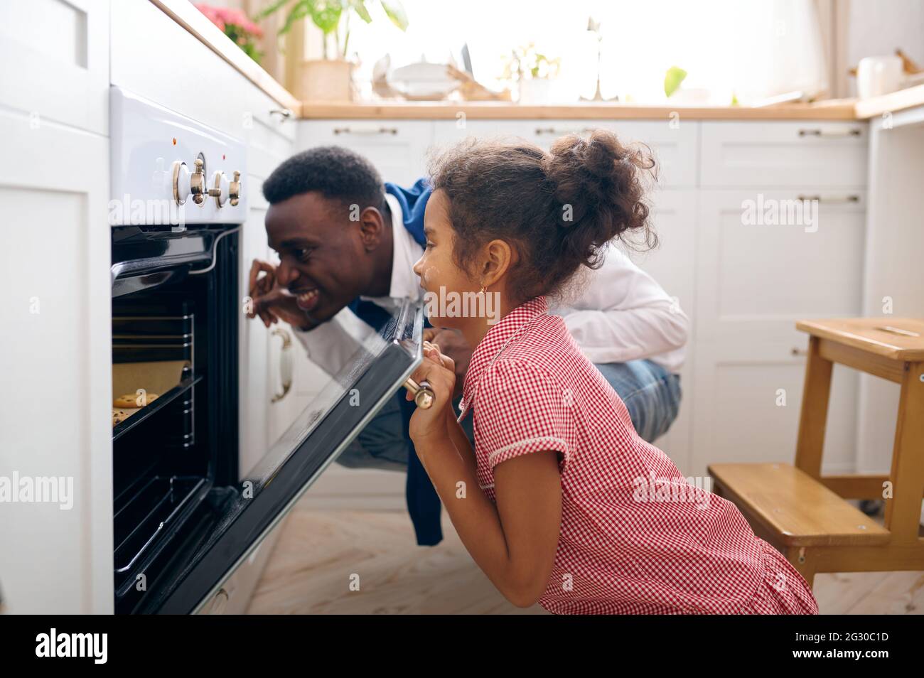 Vater und Kind beim Frühstück Kuchen im Ofen kochen Stockfoto