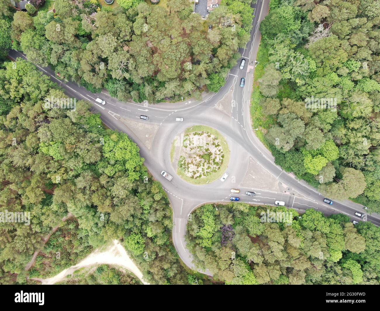 Luftaufnahme eines Straßenroundabverkehrs in einem bewaldeten und heidnischen Gebiet in Dorset Stockfoto