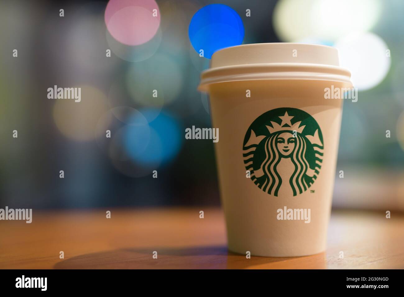 Bangkok, Thailand - 13. Juni 2021 : Starbucks weiße Papiertasse auf Holztischhintergrund mit Kopierfläche Stockfoto