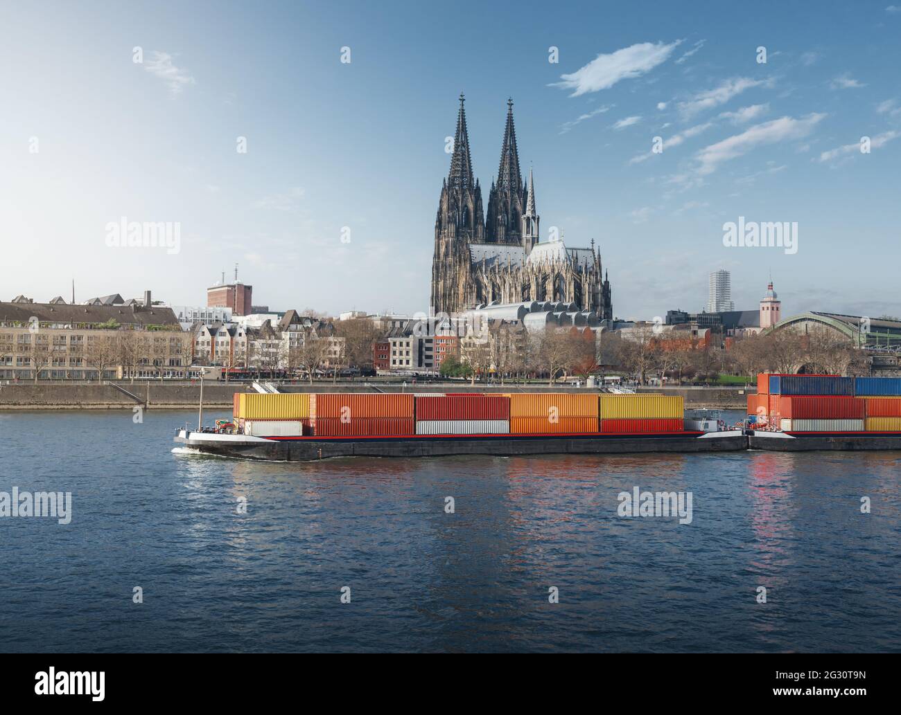 Frachtschiff, das Container auf dem Rhein transportiert, mit dem Kölner Dom im Hintergrund - Köln, Deutschland Stockfoto
