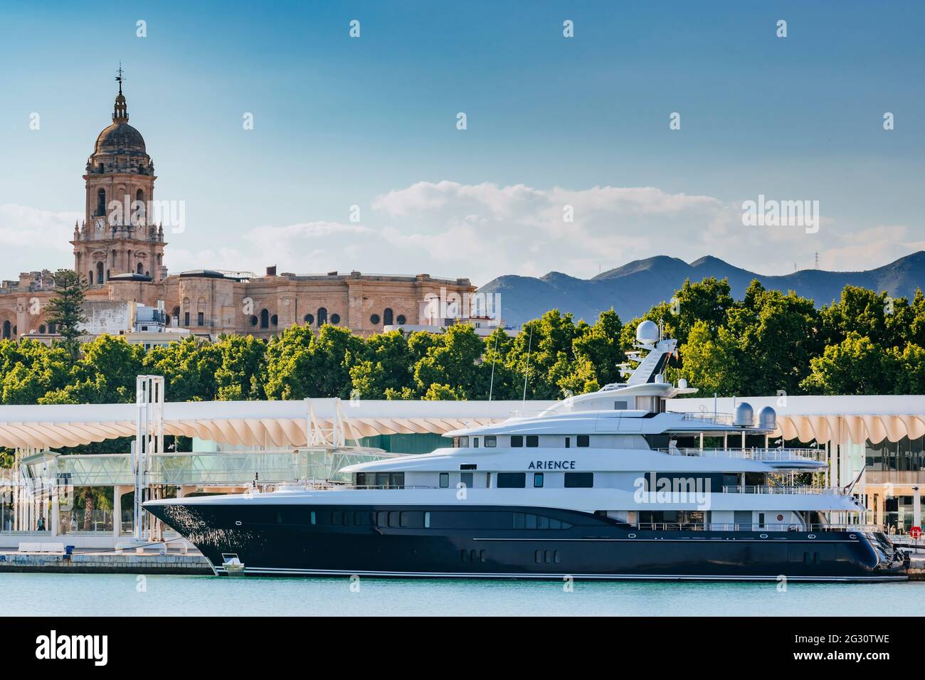 ARIENCE ist eine luxuriöse 60m Charter-Superyacht, die von Abeking & Rasmussen maßgefertigt wurde. Im Hintergrund die Kathedrale von Malaga, die sie aufsticht Stockfoto