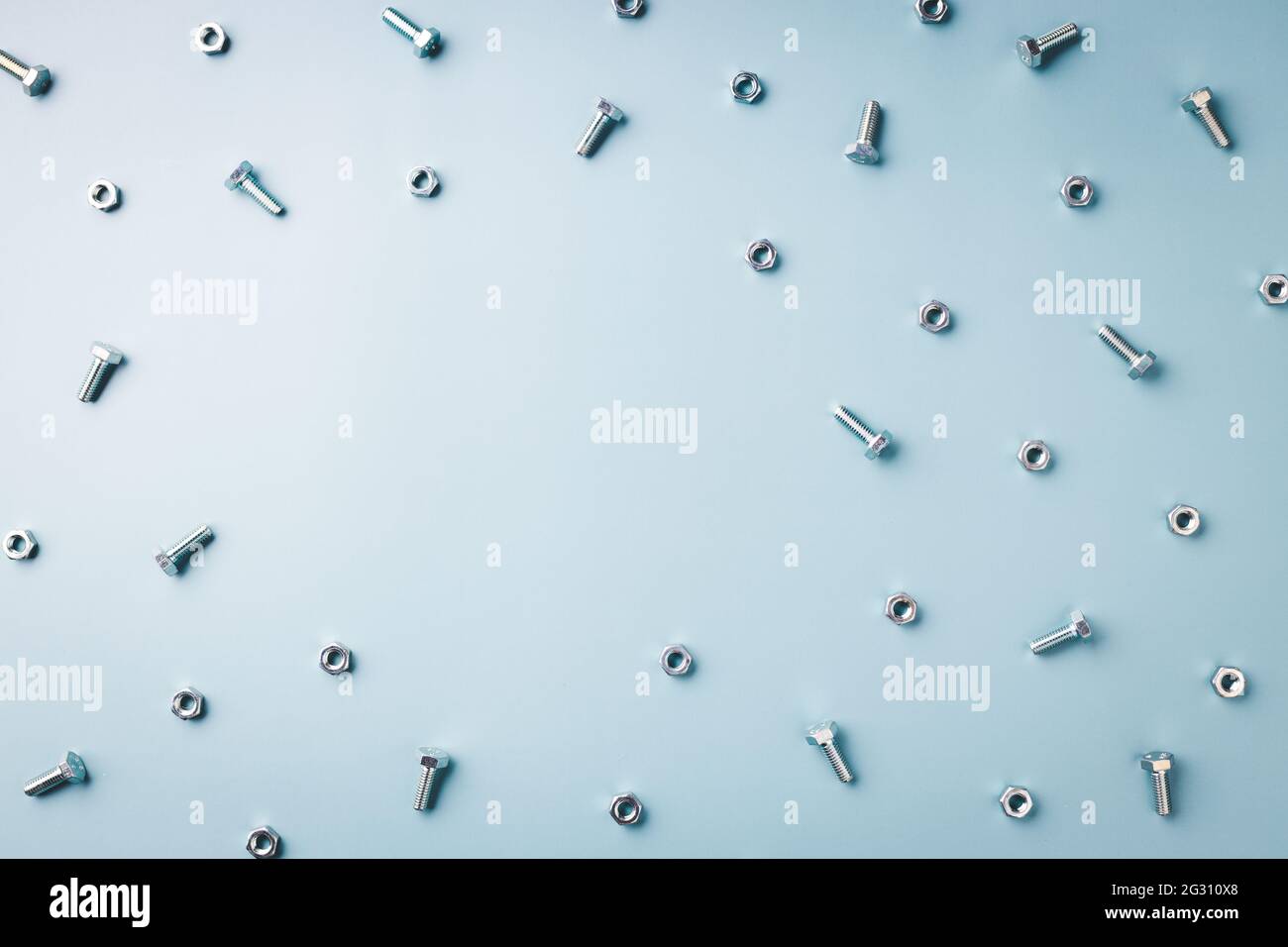 Blauer Hintergrund mit Muttern und Schrauben mit Platz für Text. Stockfoto