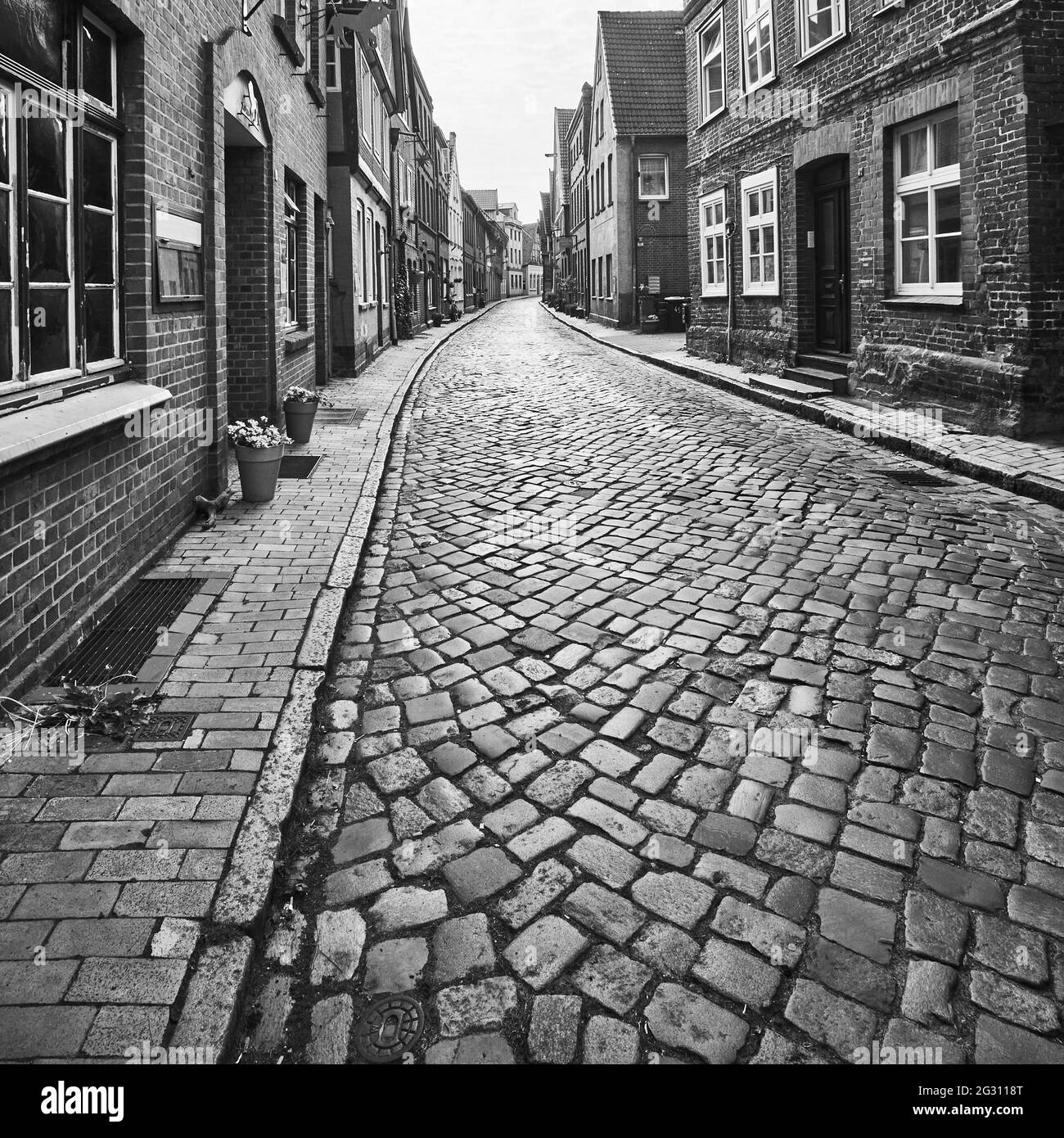 Gepflasterte Straßen und Backsteinhäuser in der historischen Altstadt von Lauenburg in Deutschland, schwarz-weiß Stockfoto