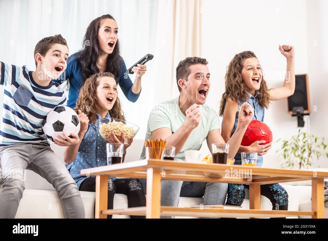 Schwärmende Fans jubeln Sport, als fünfköpfige Familie Fußball gucken,  spielen auf dem Fernseher zu Hause, schreiend vor Freude Stockfotografie -  Alamy