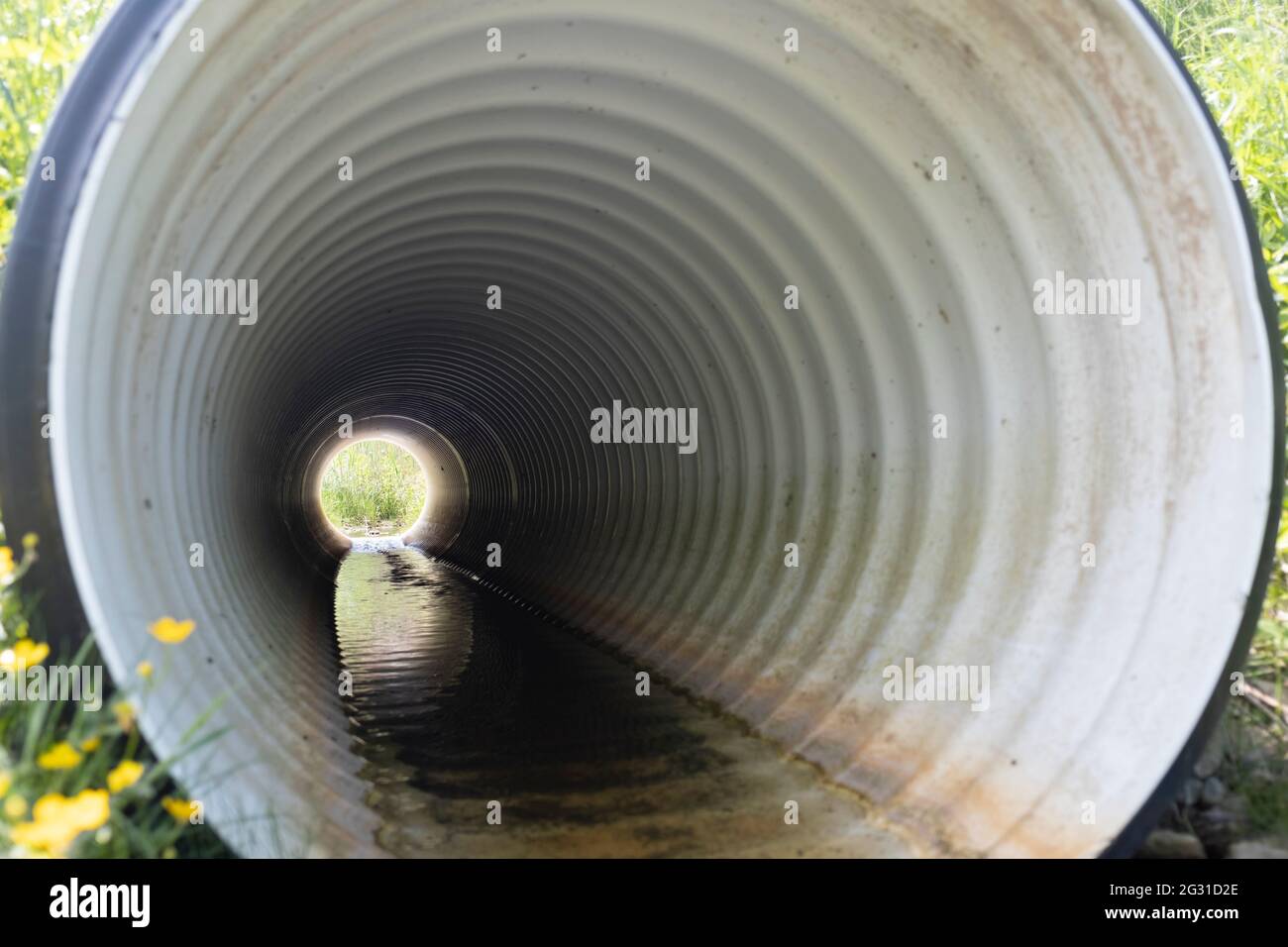 Perforiertes Entwässerungsrohr in ländlicher Umgebung installiert, Blick durch das Rohr von einem Ende zum anderen Stockfoto