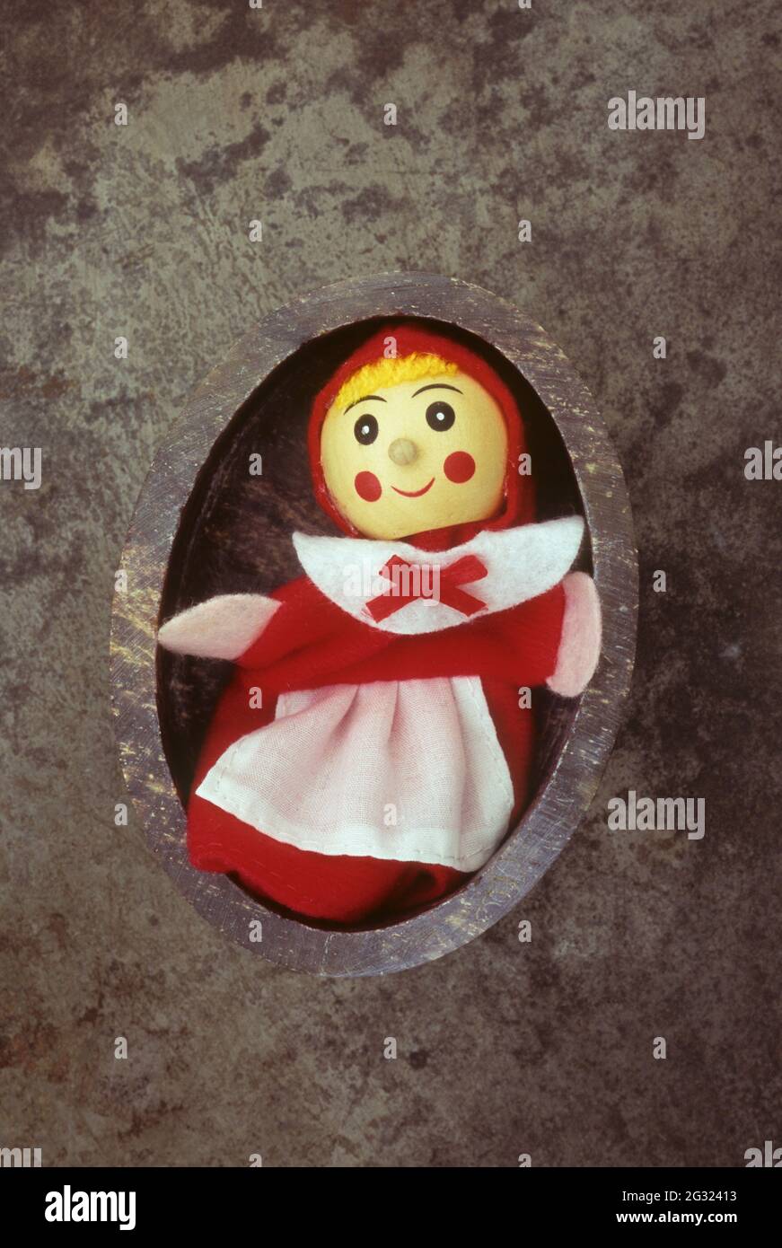 Specksteinschale mit Puppe oder Puppe mit rundem Holzkopf, frech lächelnd und rot-weißem Kleid Stockfoto