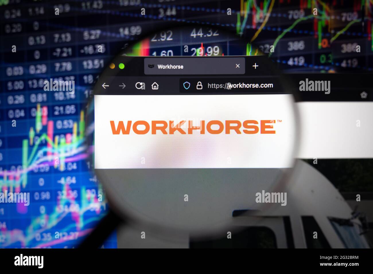 Logo des Unternehmens Workhorse auf einer Website mit verschwommenen Börsenentwicklungen im Hintergrund, die auf einem Computerbildschirm durch eine Lupe gesehen werden Stockfoto