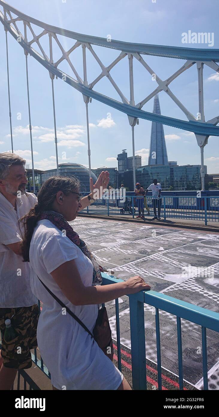 Tower Bridge, London, 13. Juli 2021. Inside Out Project Kunstausstellung im Freien mit Porträts von Londoner, die auf der Tower Bridge auf die Straße geklebt wurden. Stockfoto