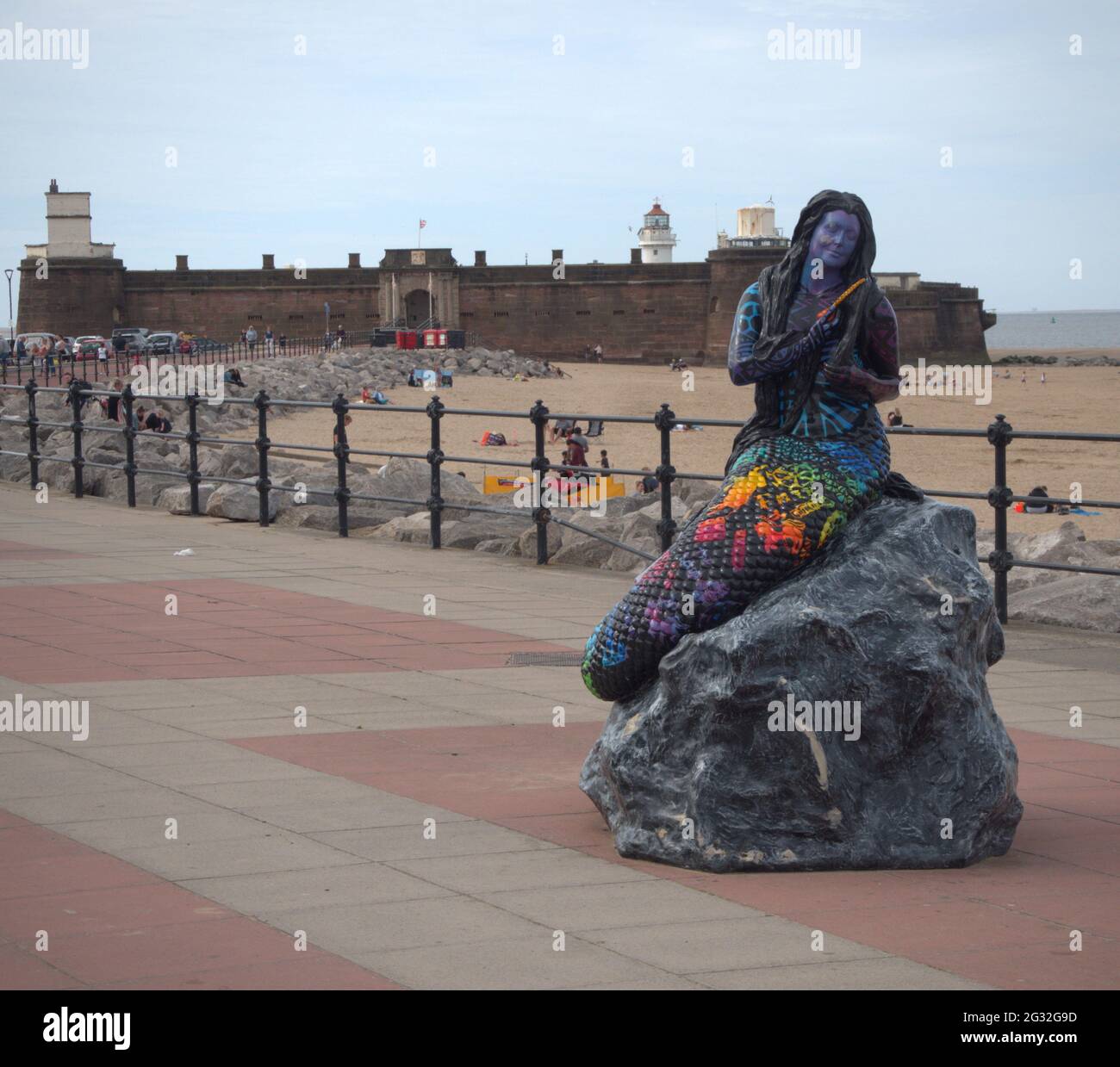 Statue der Meerjungfrau auf der Marine Parade in New Brighton mit Fort Rock Barch im Hintergrund, entworfen vom lokalen Künstler Barry Canning-Eaton Stockfoto